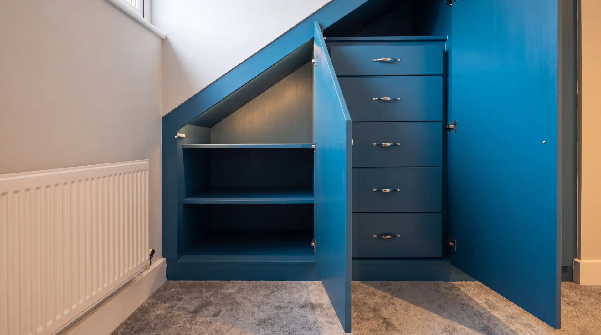 Built-in alcove shelving and cupboards beside a chimney breast
